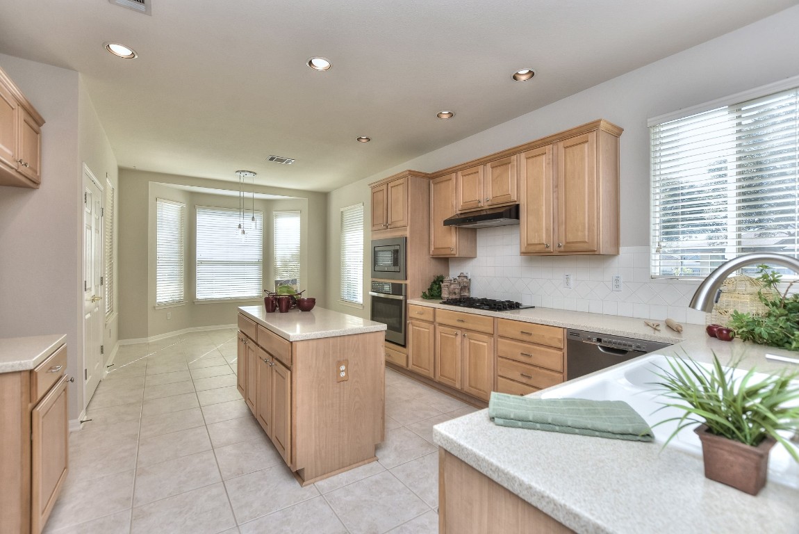 a kitchen with a sink stove and cabinets