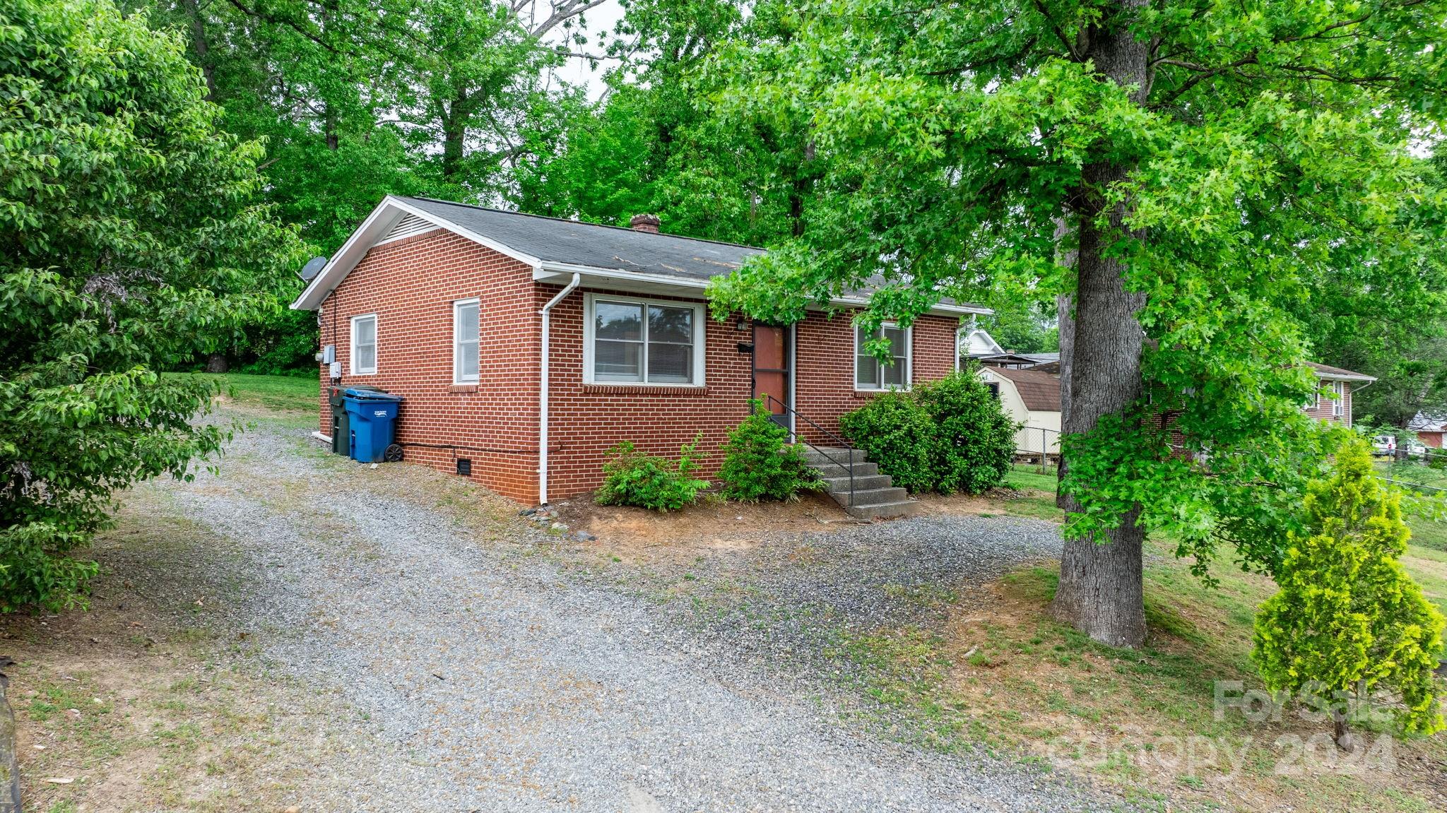 a view of a house with a yard and large tree