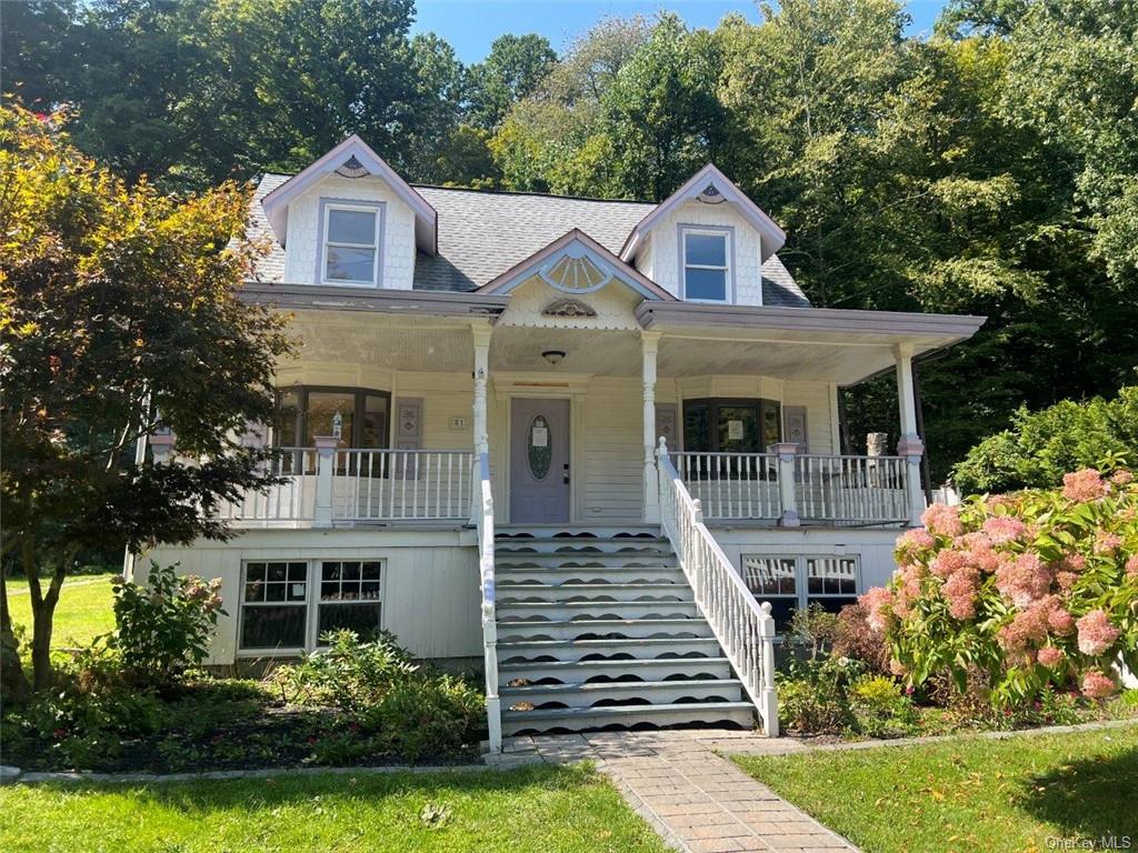 View of front of home with a front yard and covered porch