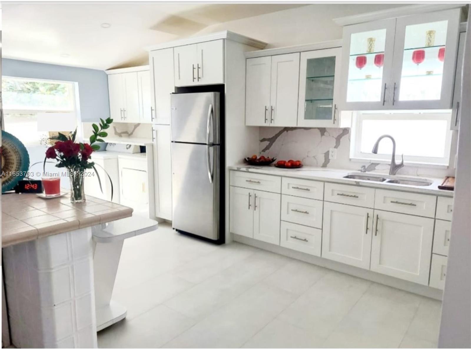 Renovated modern kitchen, where sleek design meets functionality. Custom cabinetry provides ample storage space and adds a refined, contemporary touch, while stainless steel appliances offer a professional-grade cooking experience.