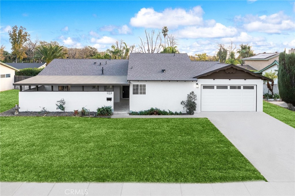 a front view of a house with a garden and trees