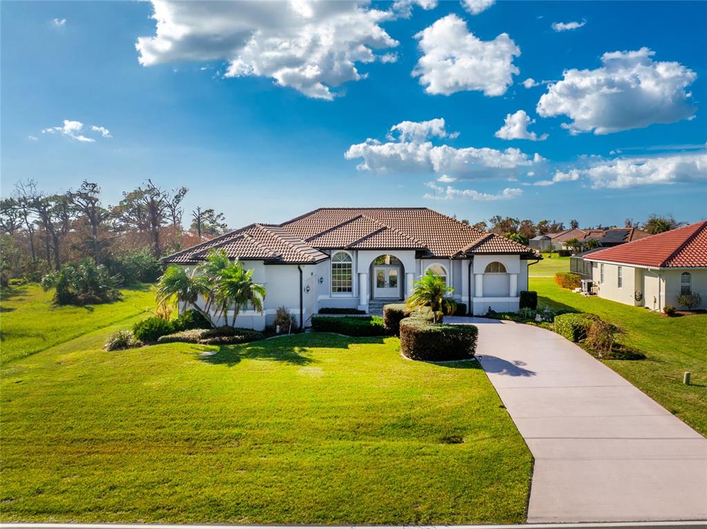 a view of a house with swimming pool lawn chairs and a yard