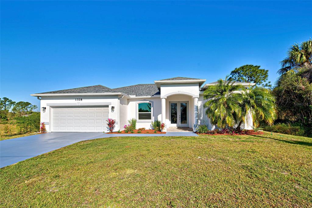 a view of a house with a patio and a yard