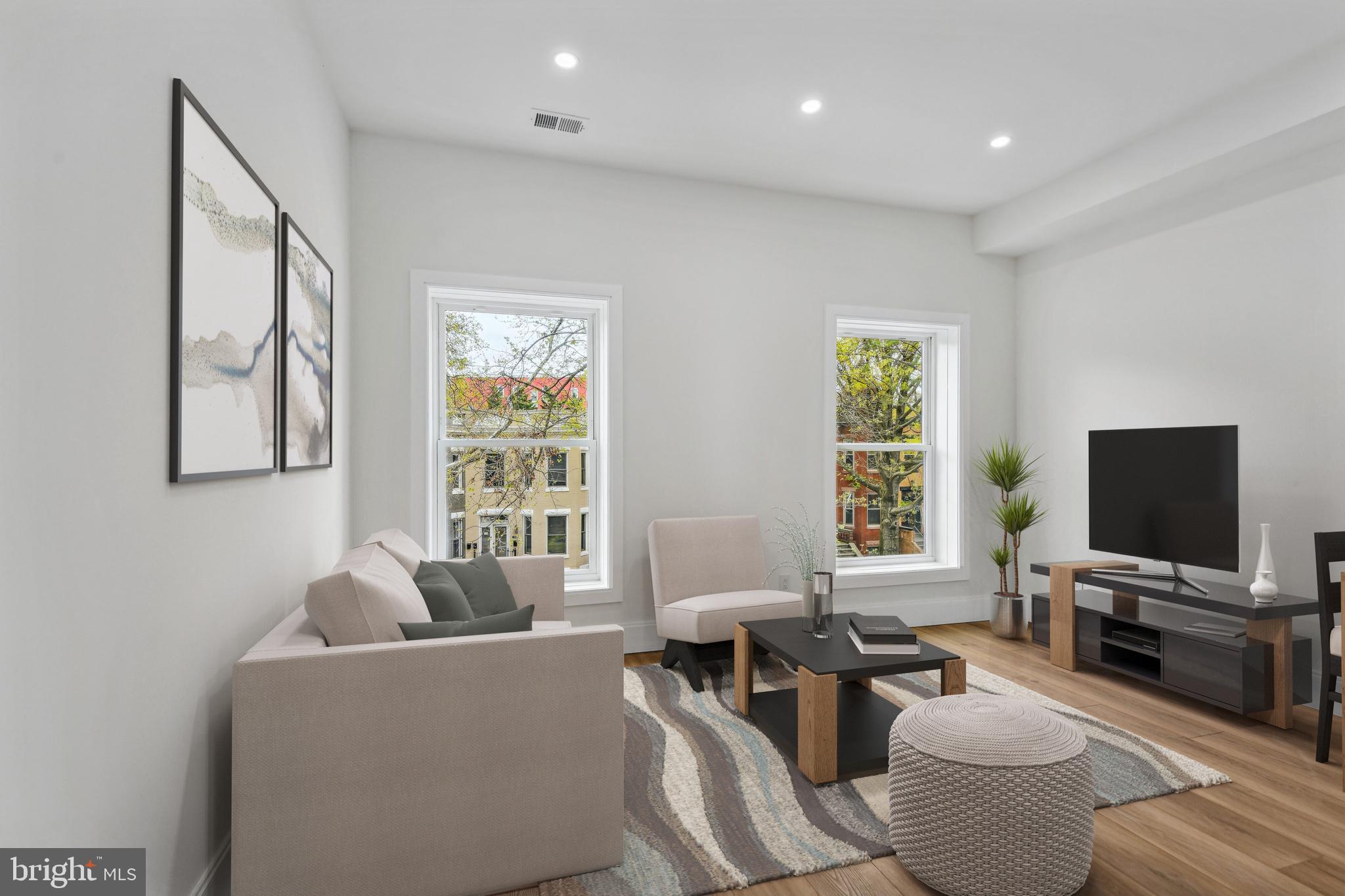 a living room with furniture a flat screen tv and a window