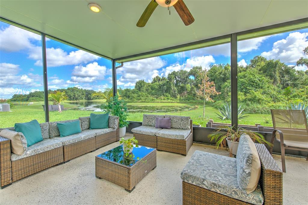 a living room with patio furniture and a garden