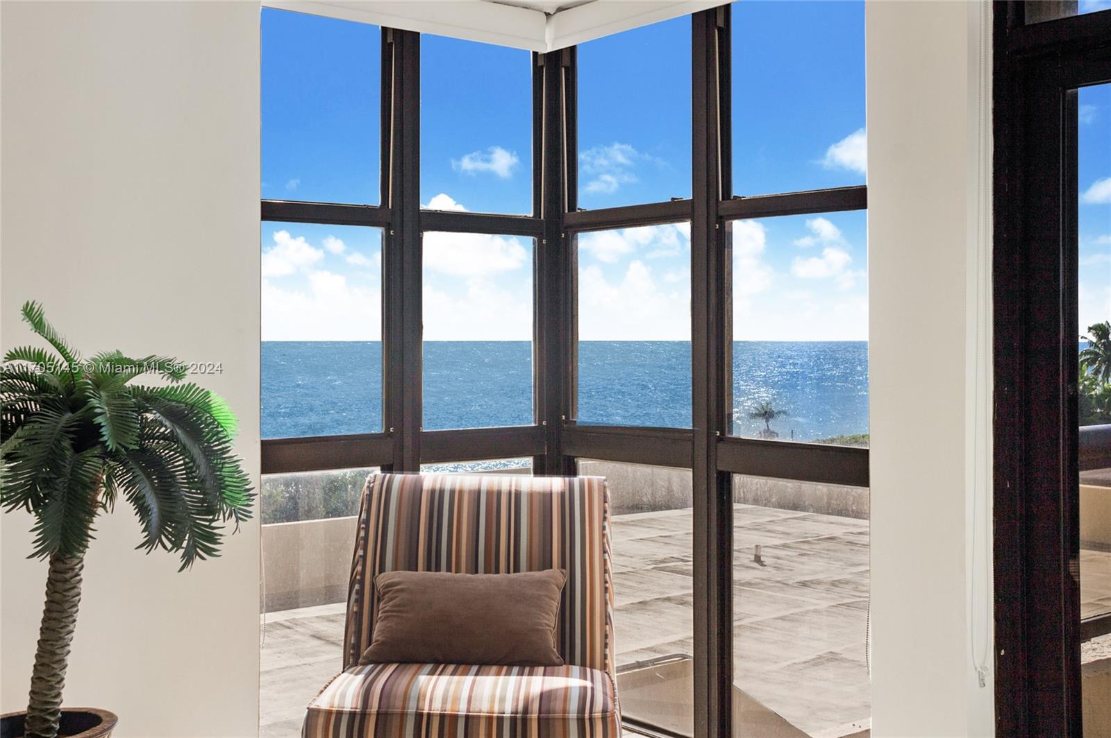 a view of a balcony with furniture and floor to ceiling window