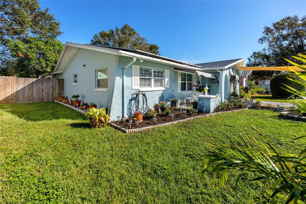 a view of a house with backyard sitting area and garden