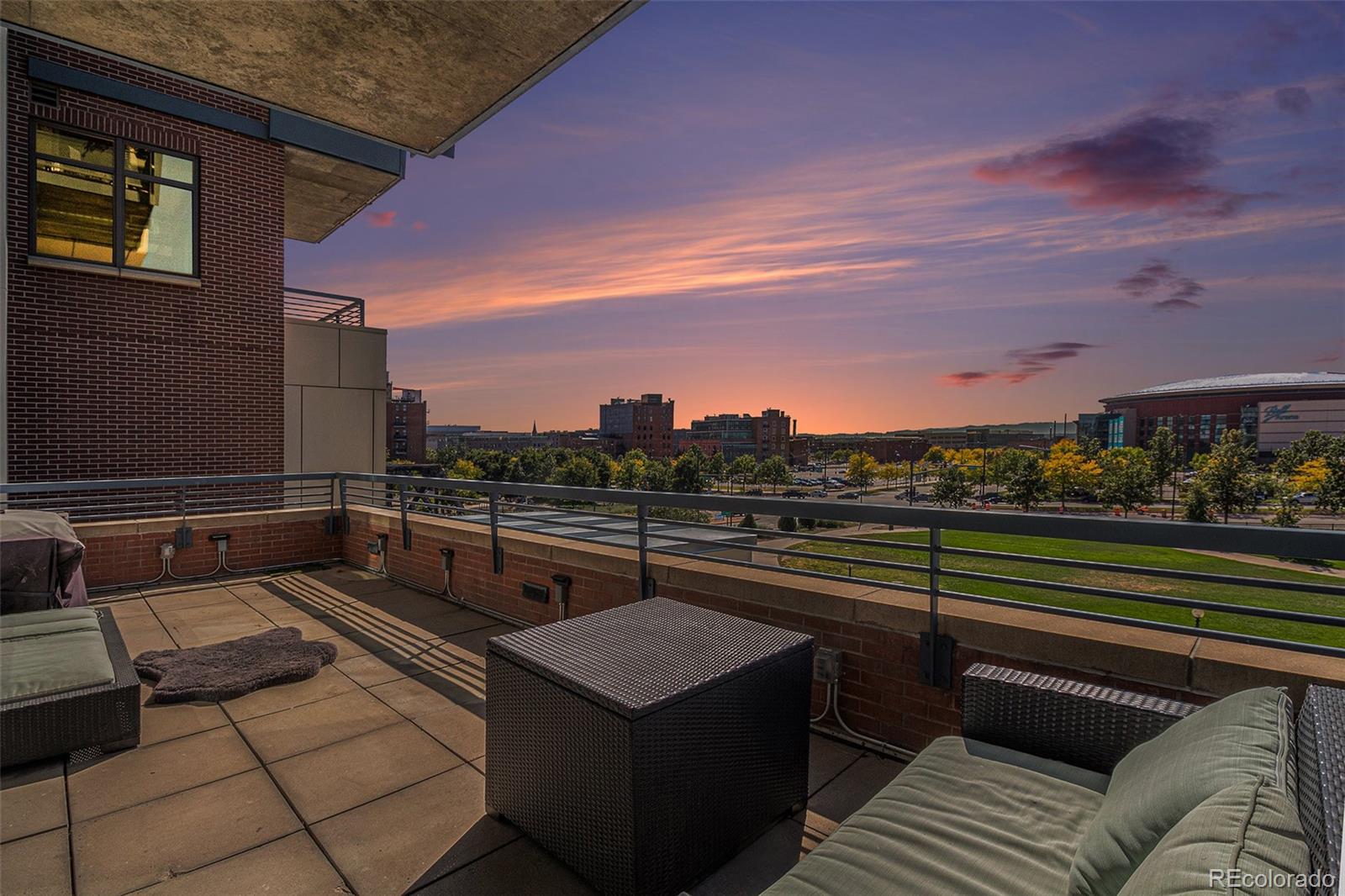 a view of a roof deck with couches and sky view