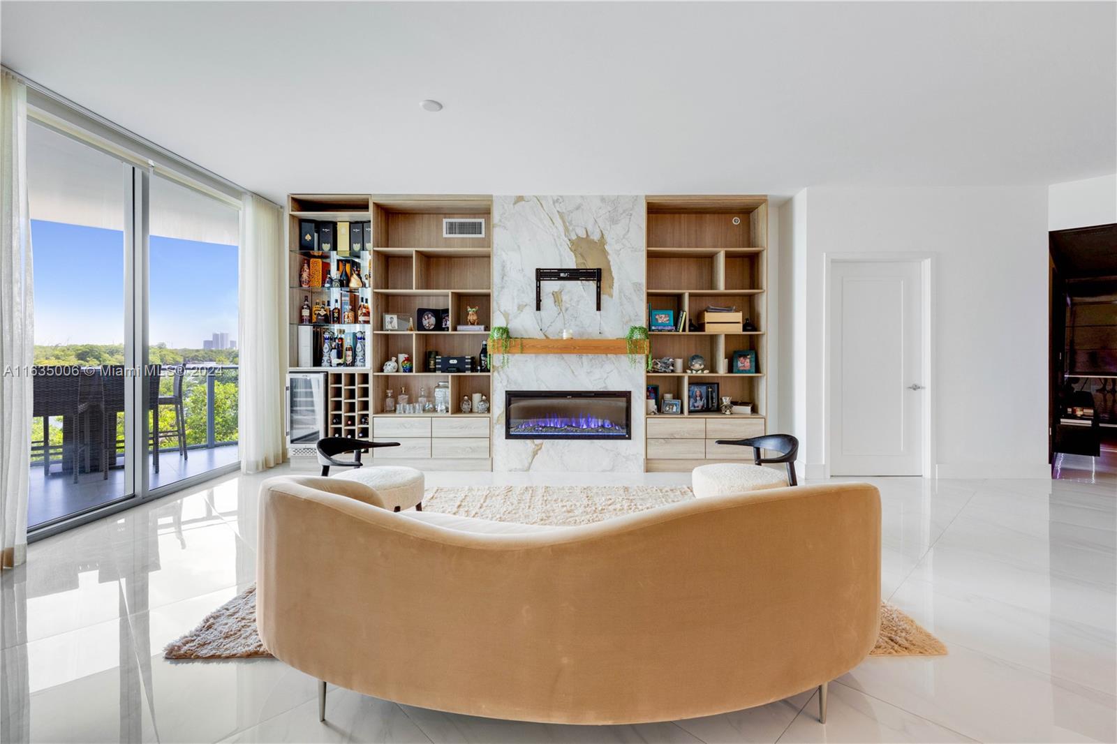 a living room with fireplace furniture and a large window