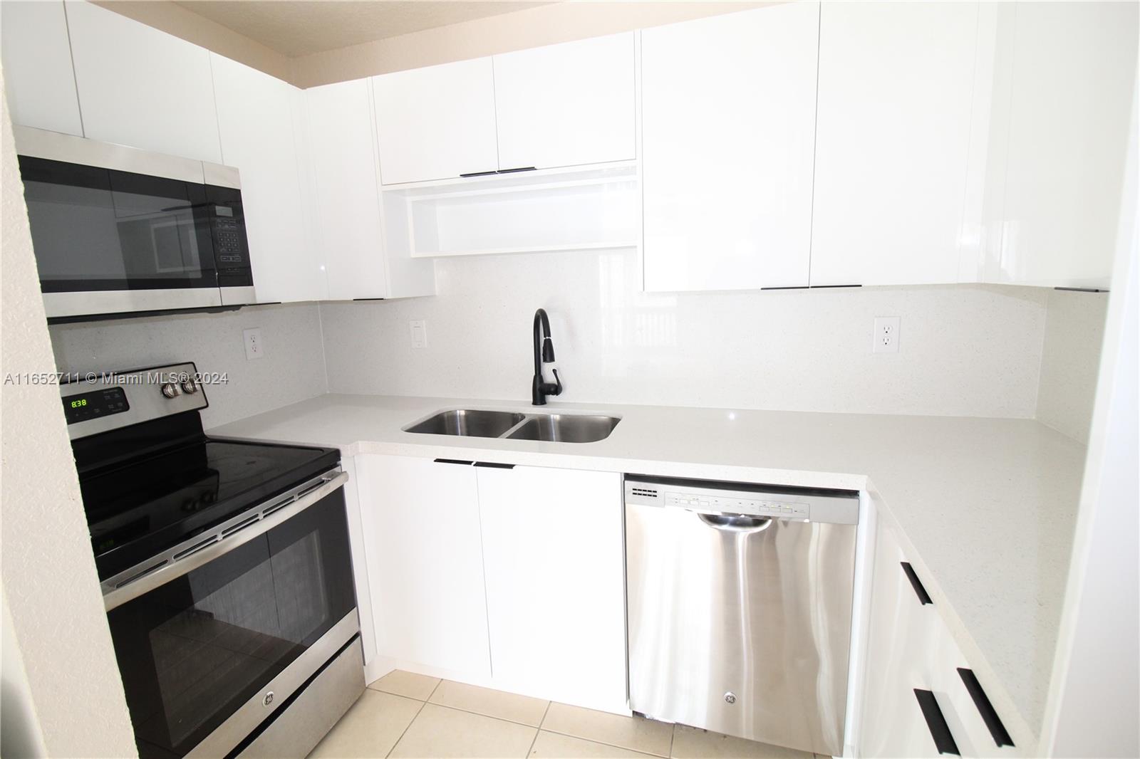 a kitchen with a sink stove and microwave