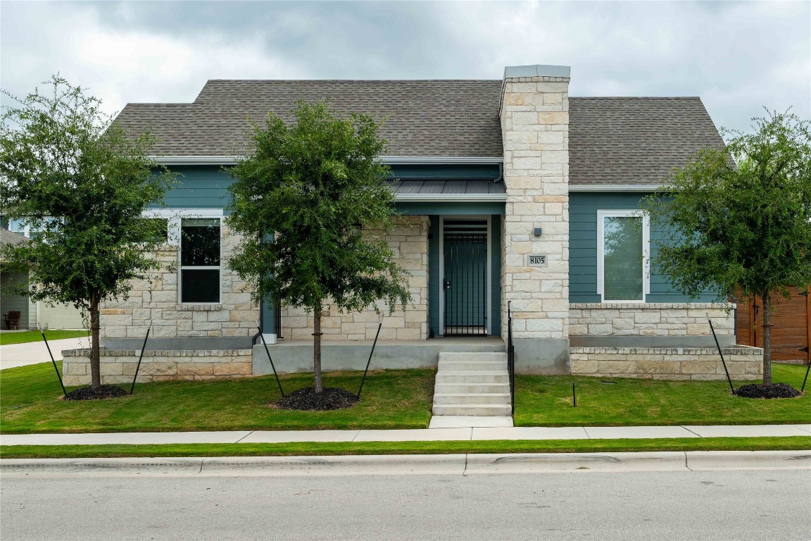 a front view of a house with a garden and plants