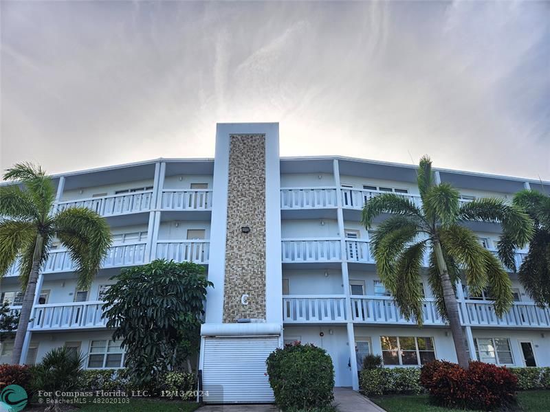 a front view of a building with palm tree