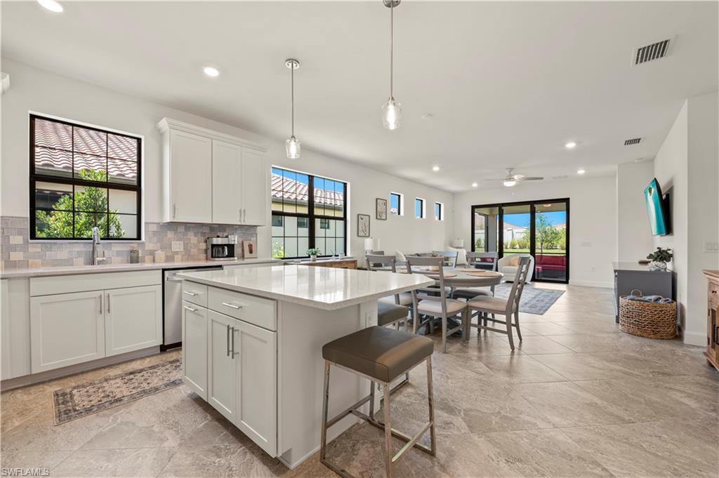 a large kitchen with kitchen island a table and chairs in it