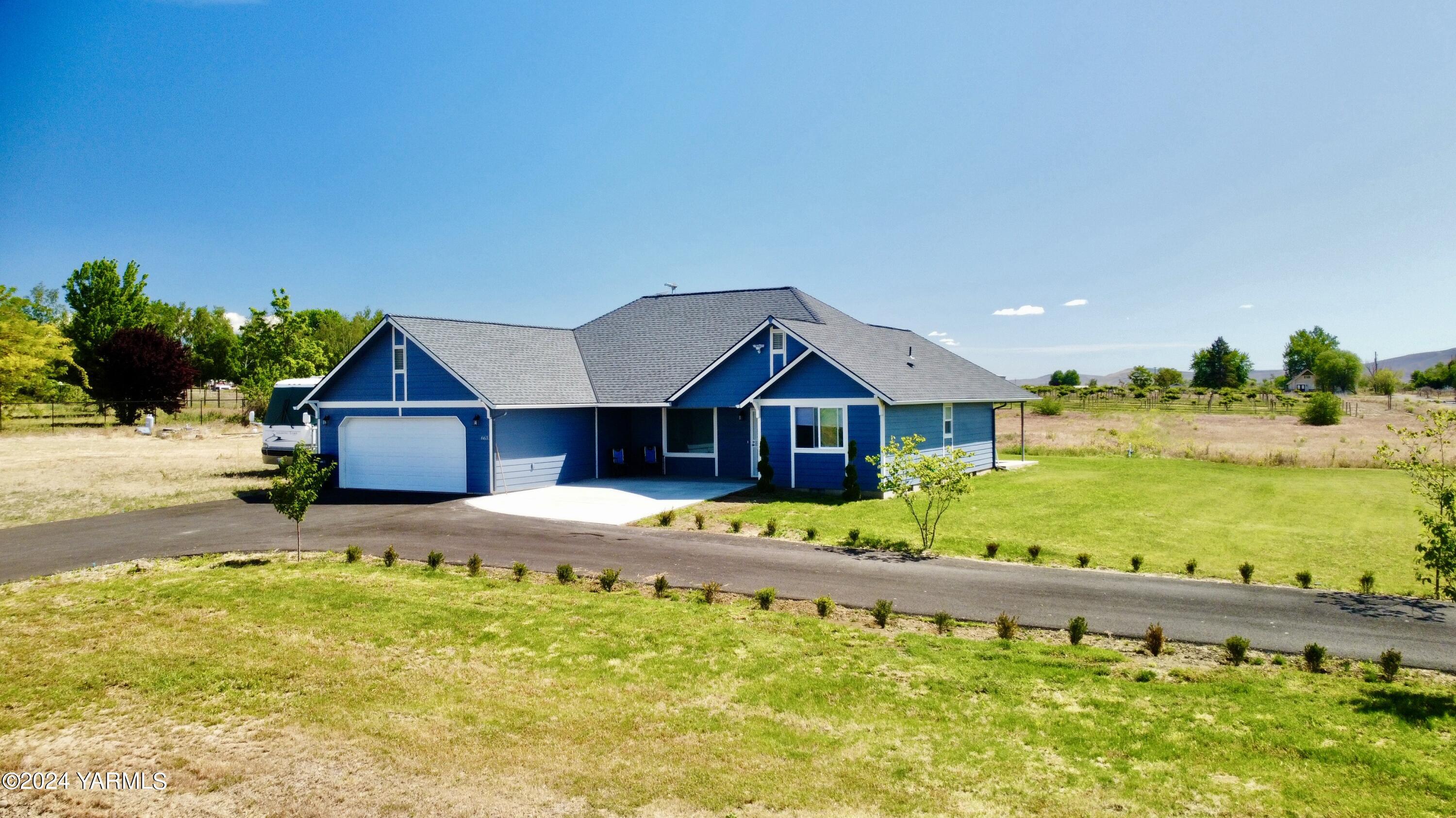 a front view of a house with a yard and ocean view