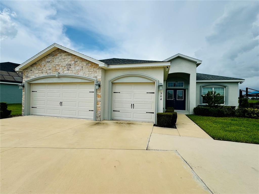 a front view of a house with a yard and garage