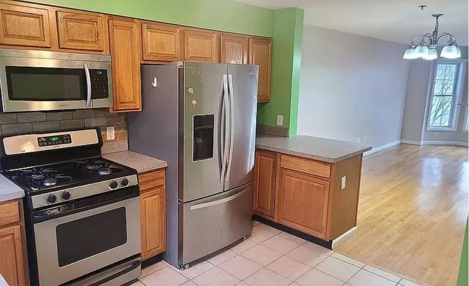 a kitchen with stainless steel appliances granite countertop a refrigerator stove and microwave