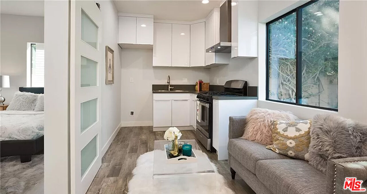 a living room with stainless steel appliances furniture and a large window