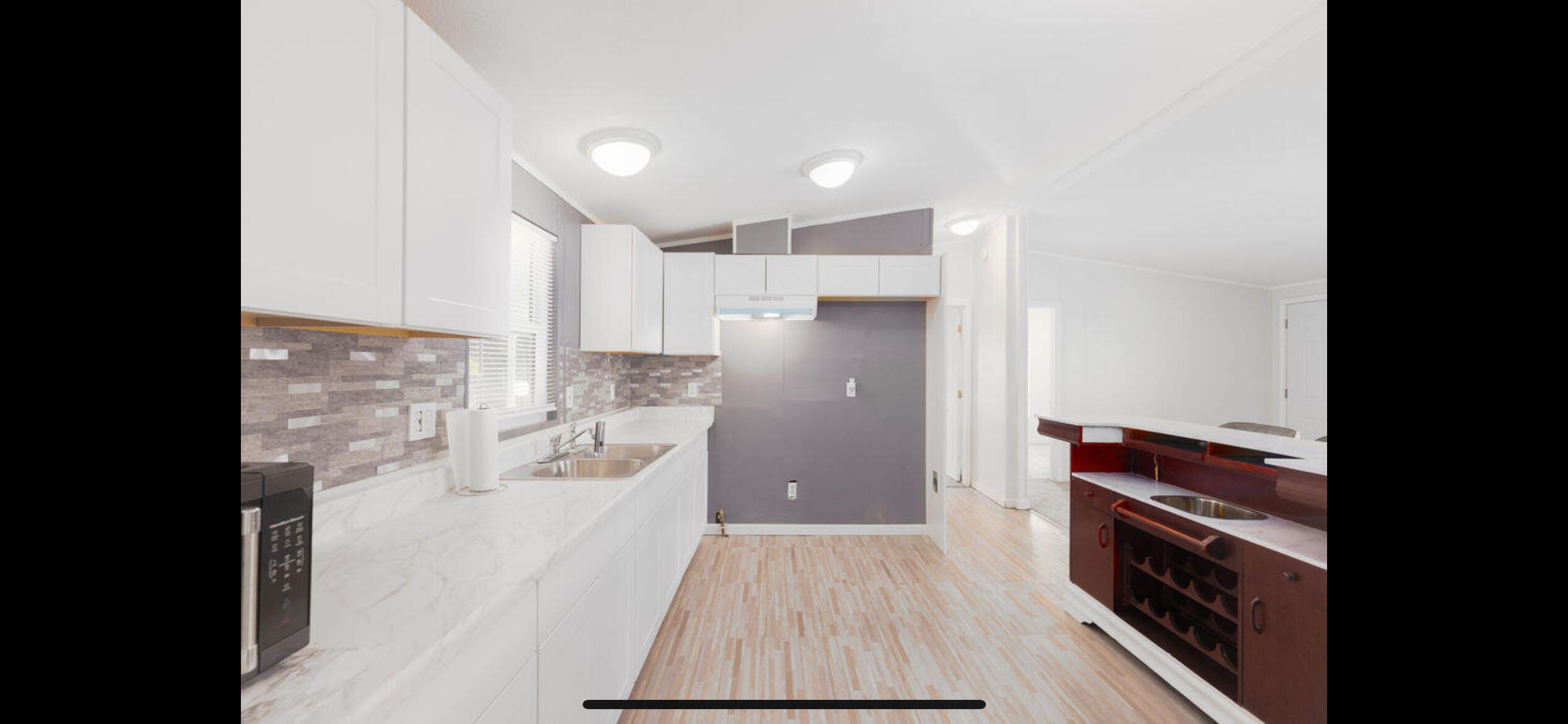 a kitchen with kitchen island wooden floors granite counter tops and white appliances