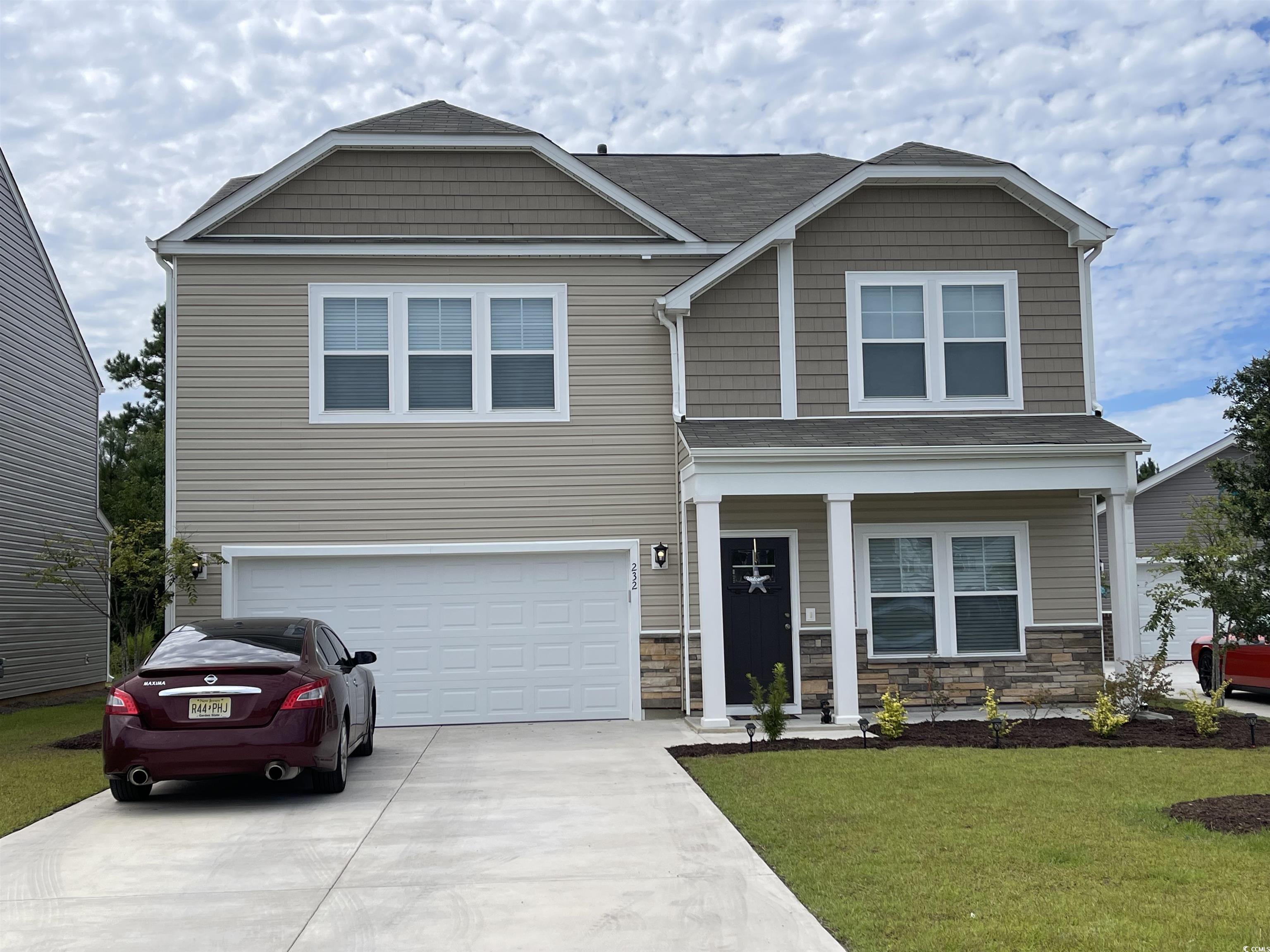 View of front of house with a garage and a front y