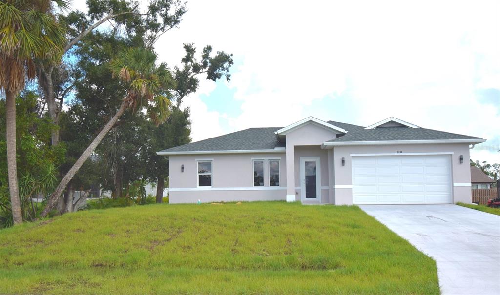 a view of a house with a yard and large tree