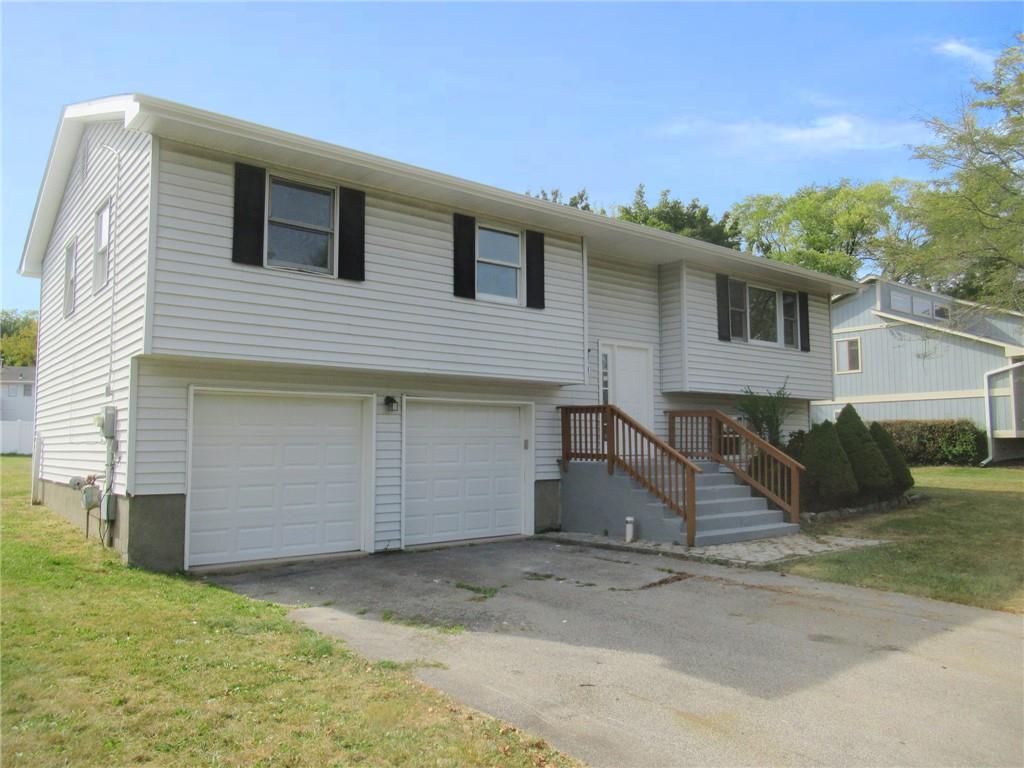 Bi-level home with a garage and a front lawn