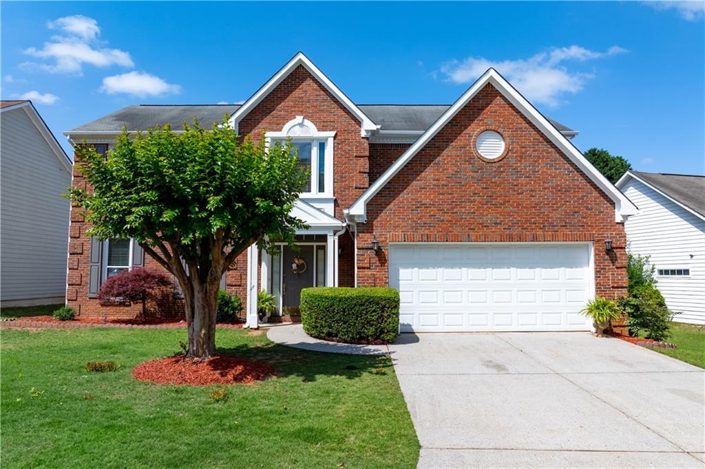 a front view of a house with a yard and garage