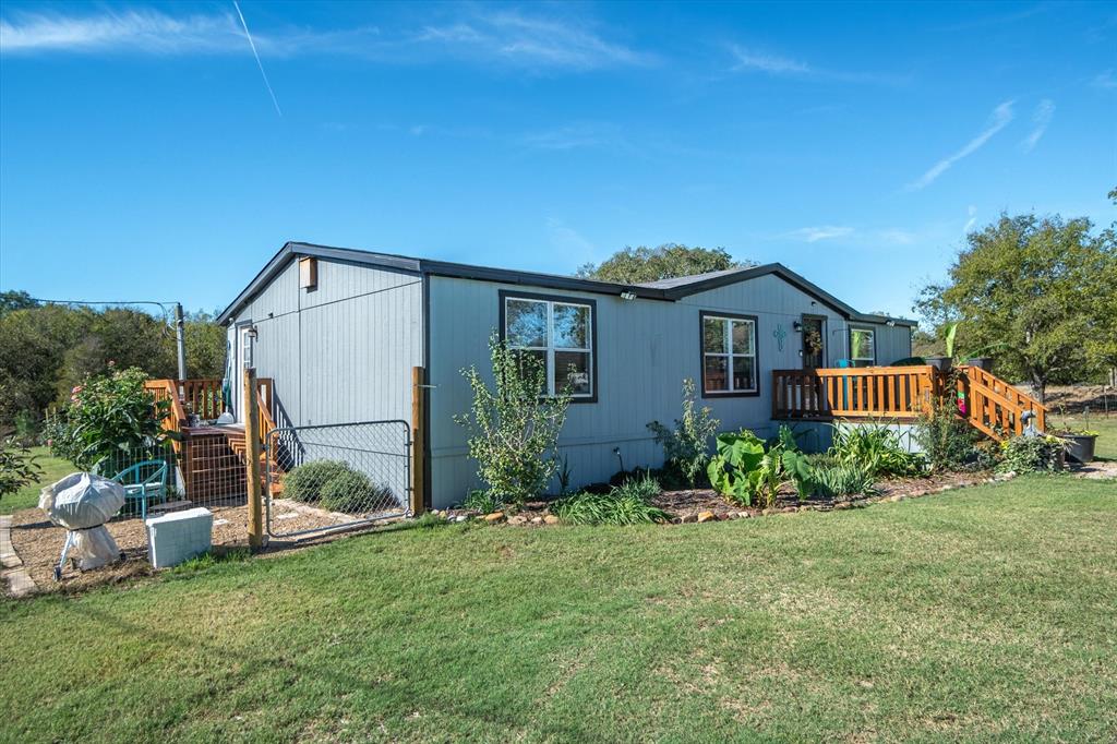 Rear view of property with a lawn and a wooden deck