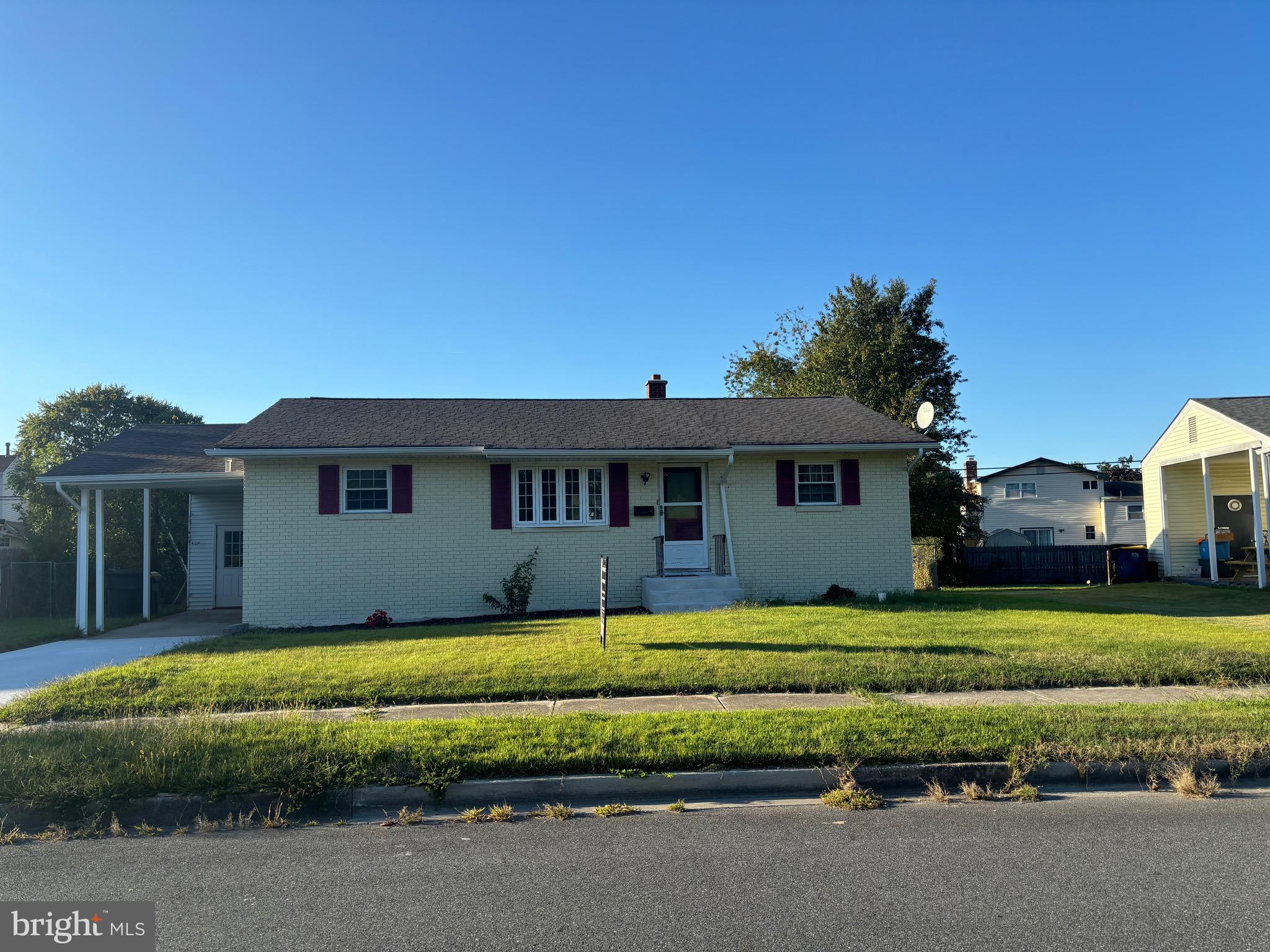 a view of a house with a big yard and large tree