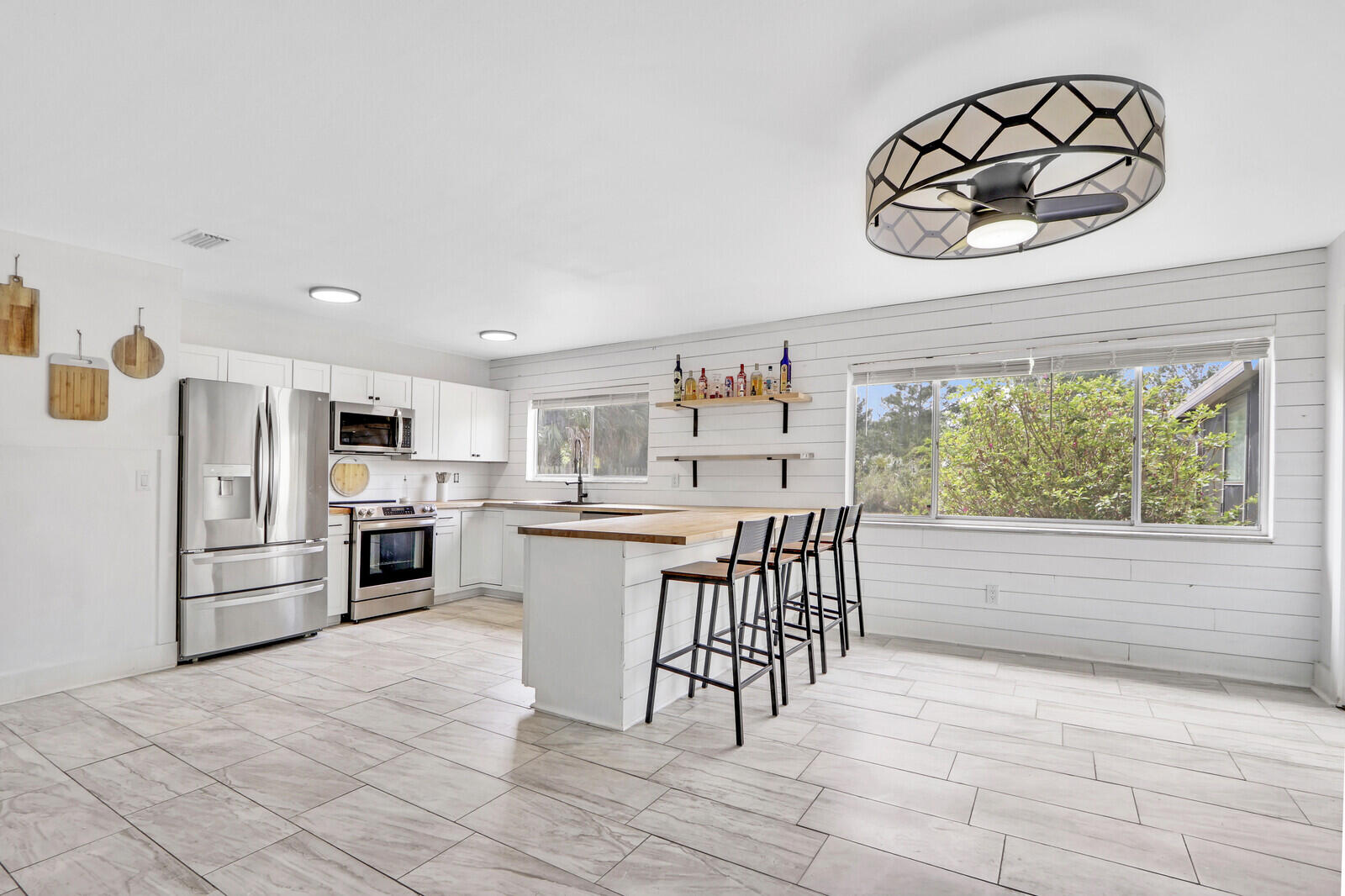 a kitchen with stainless steel appliances a white table chairs and a refrigerator