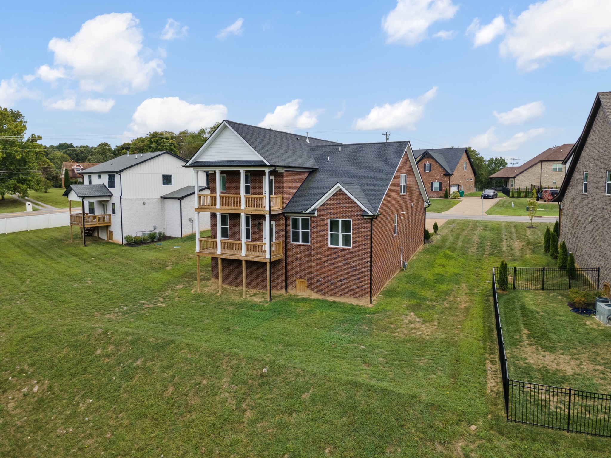 a aerial view of a house next to a big yard and large trees