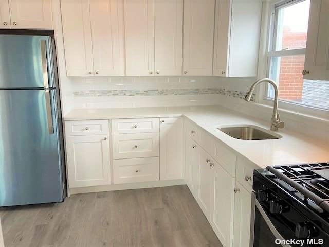 a kitchen with granite countertop a sink stove and refrigerator