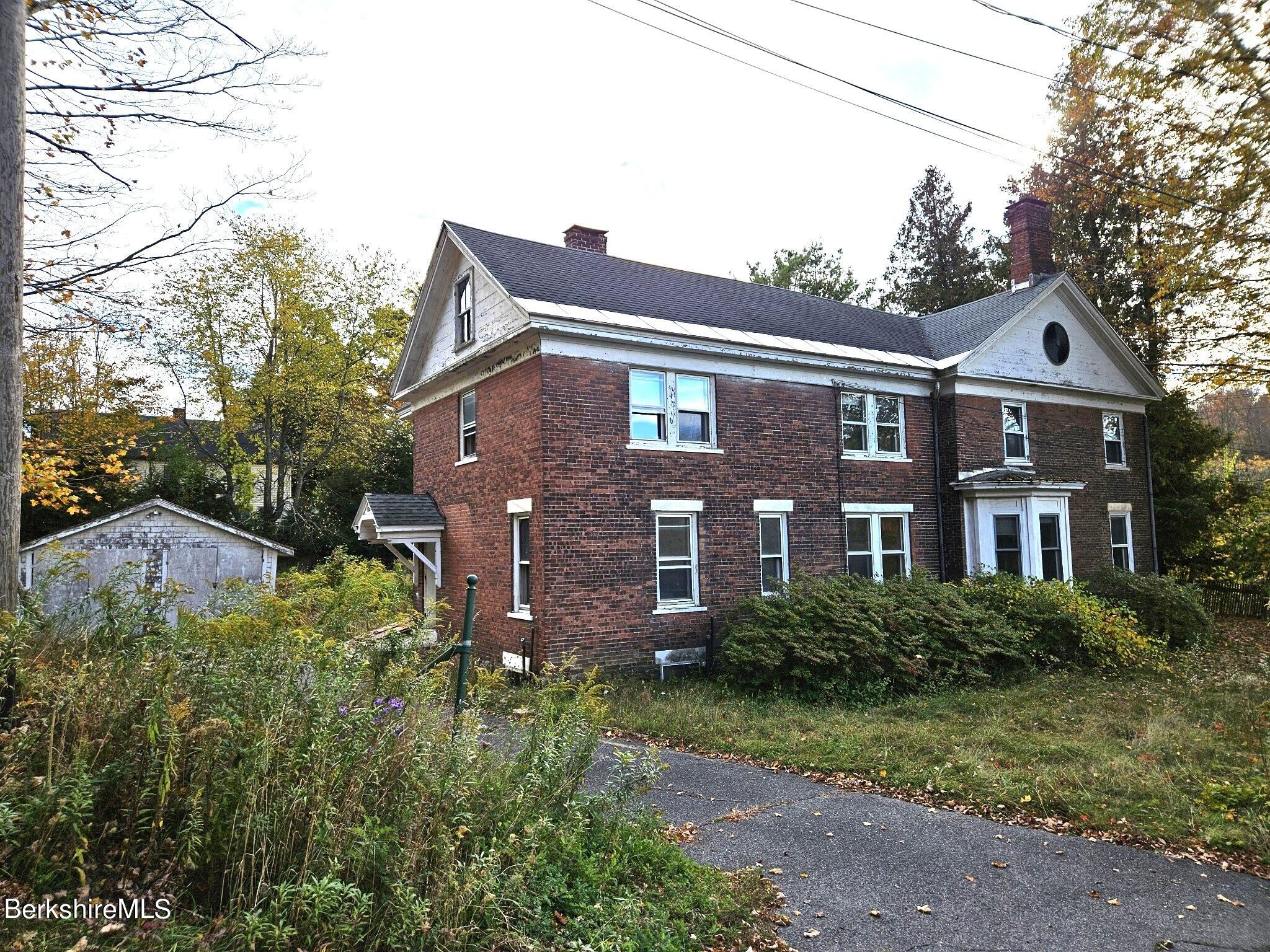 a front view of a house with a yard and trees