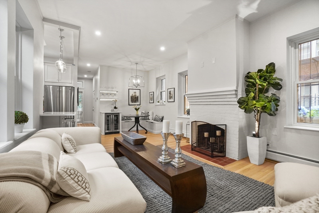 a living room with furniture a fireplace and a chandelier