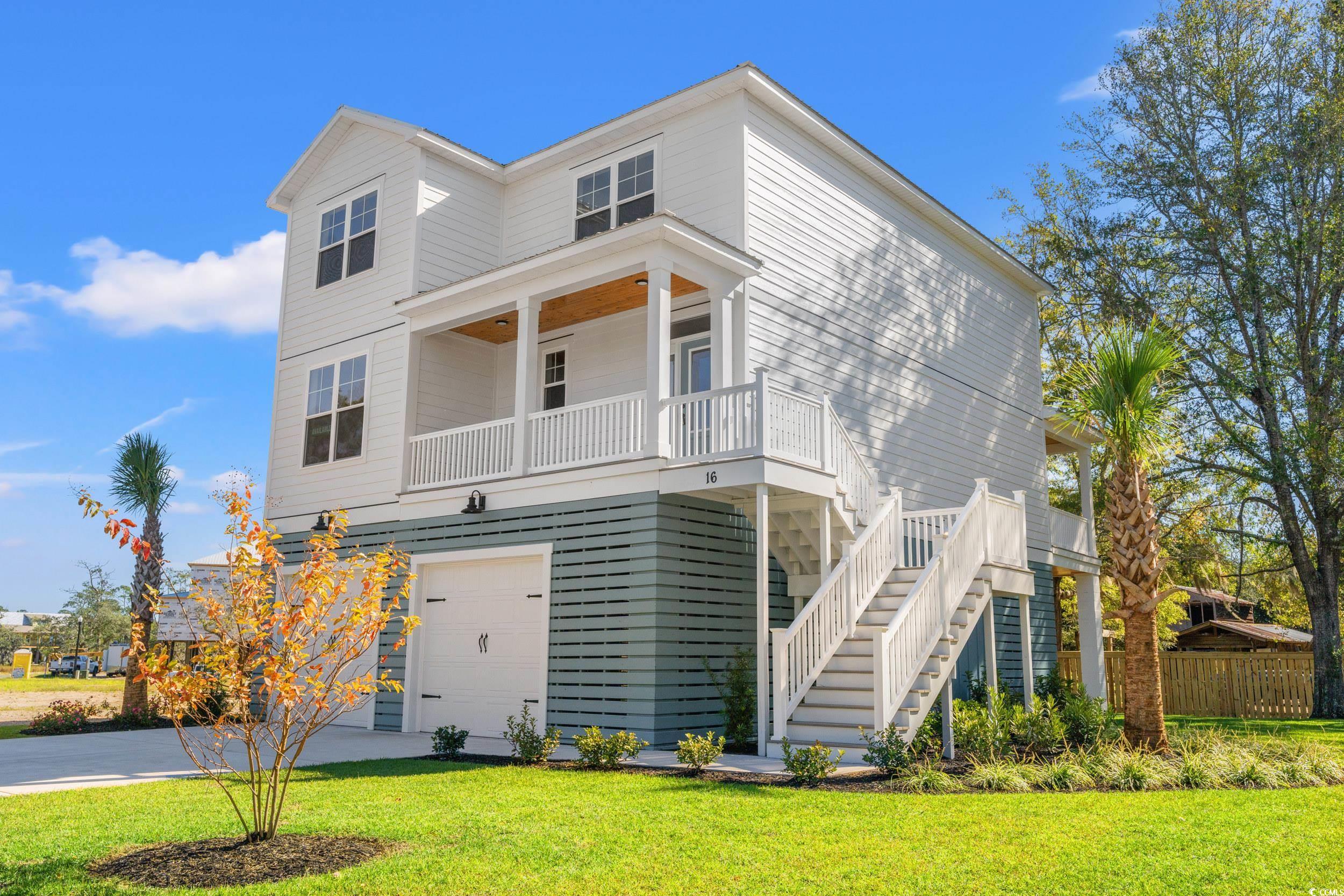 Rear view of property with covered porch, a yard,