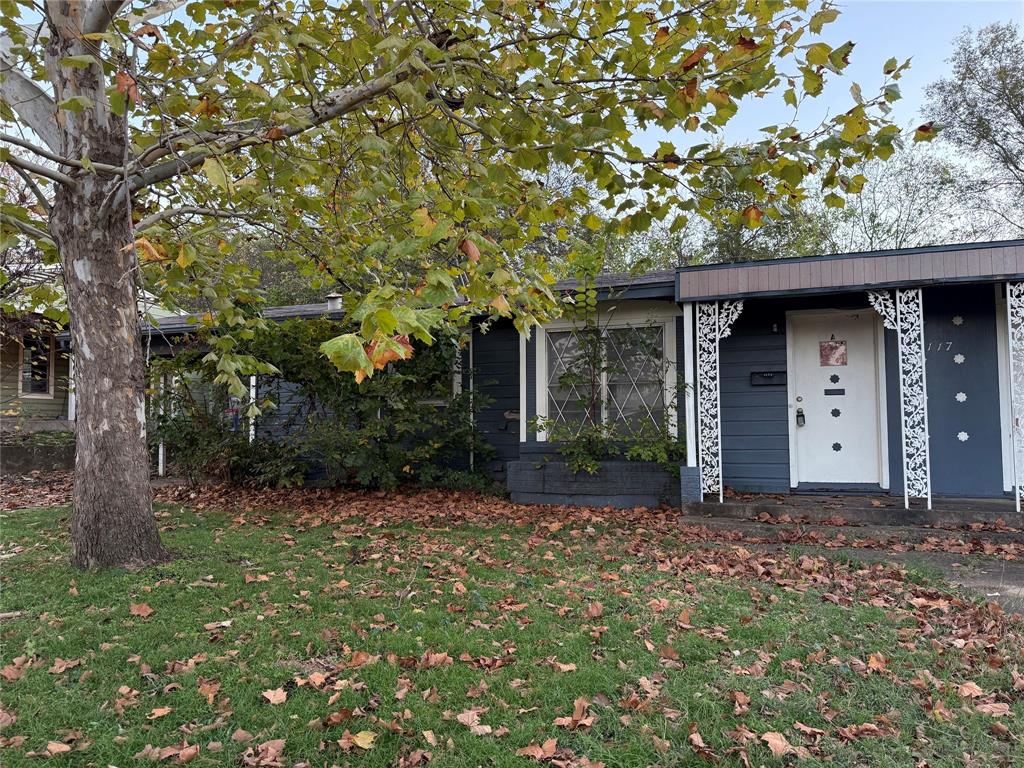 a front view of a house with a tree