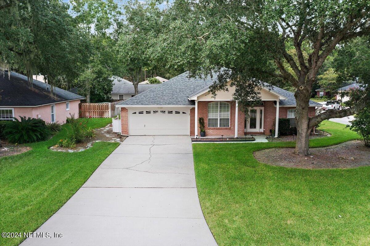 a front view of a house with a garden and trees