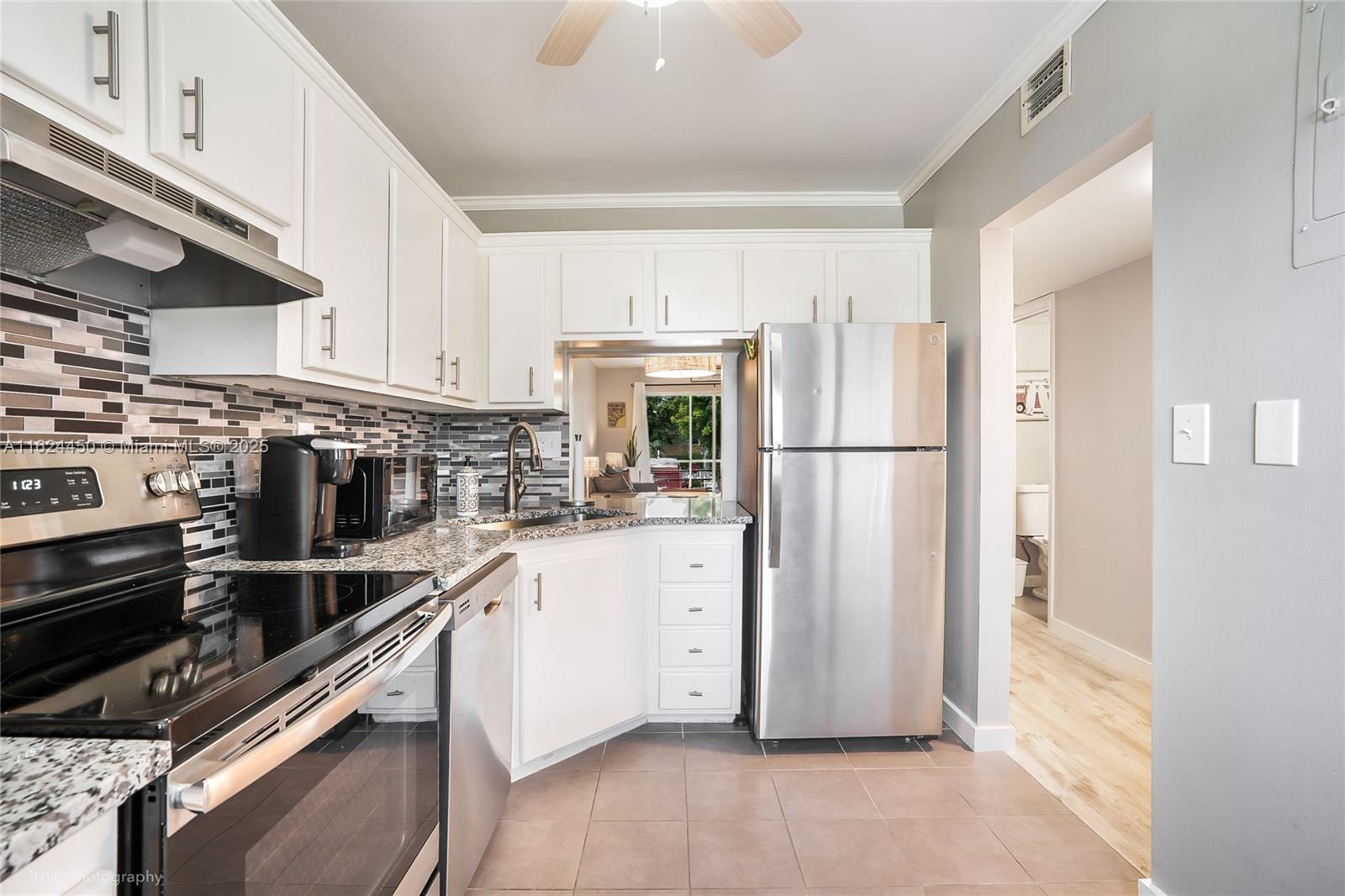 a kitchen with a refrigerator and white cabinets