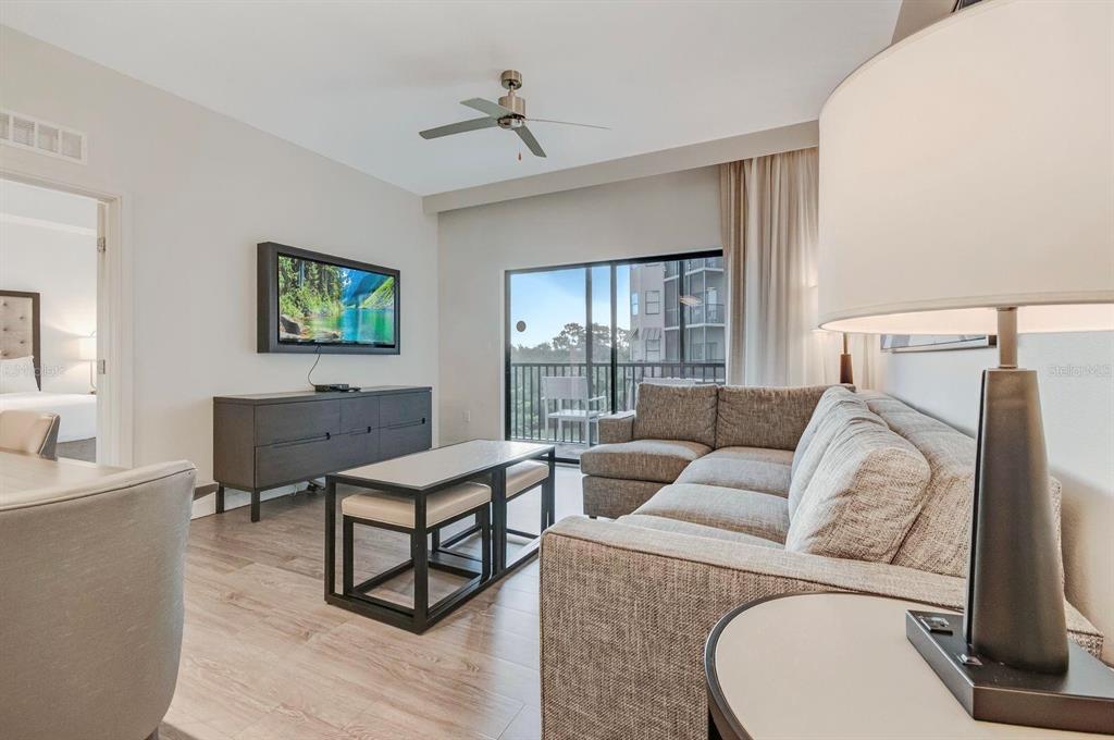 a living room with furniture a flat screen tv and a window