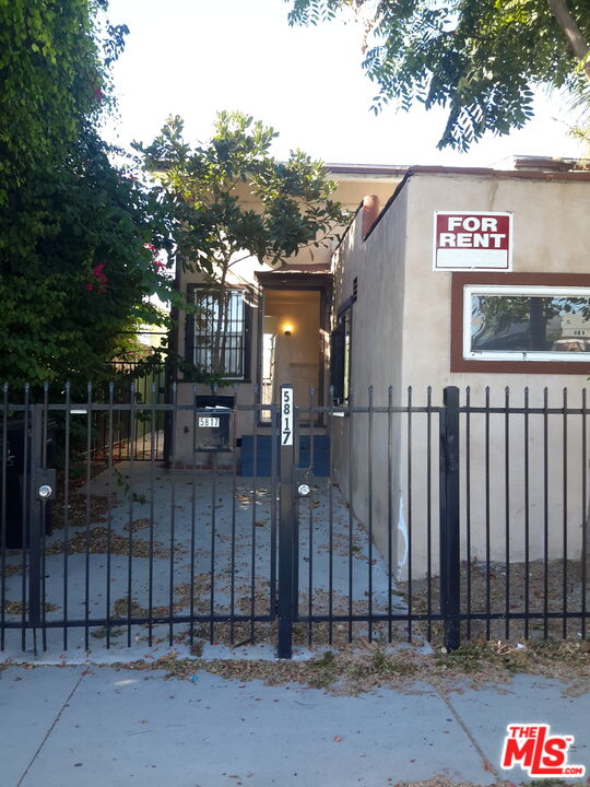 a view of a entrance gate of the house and tree