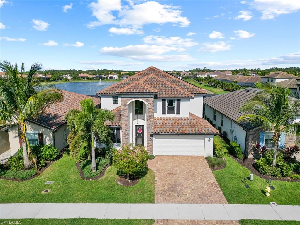 Mediterranean / spanish home with a 3 car tandem garage and a front lawn