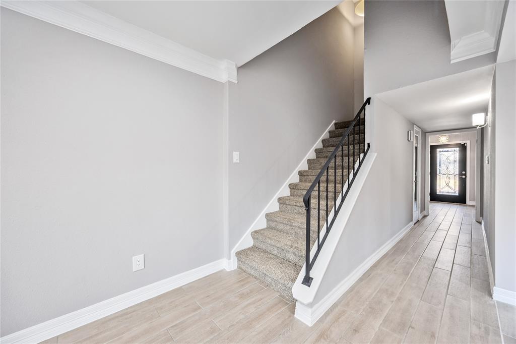 a view of a hallway with wooden floor and staircase