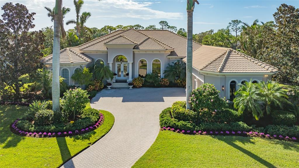 a view of a white house with a big yard and potted plants