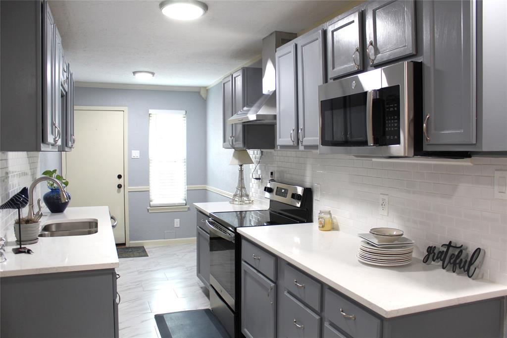 a kitchen with a sink stove and cabinets