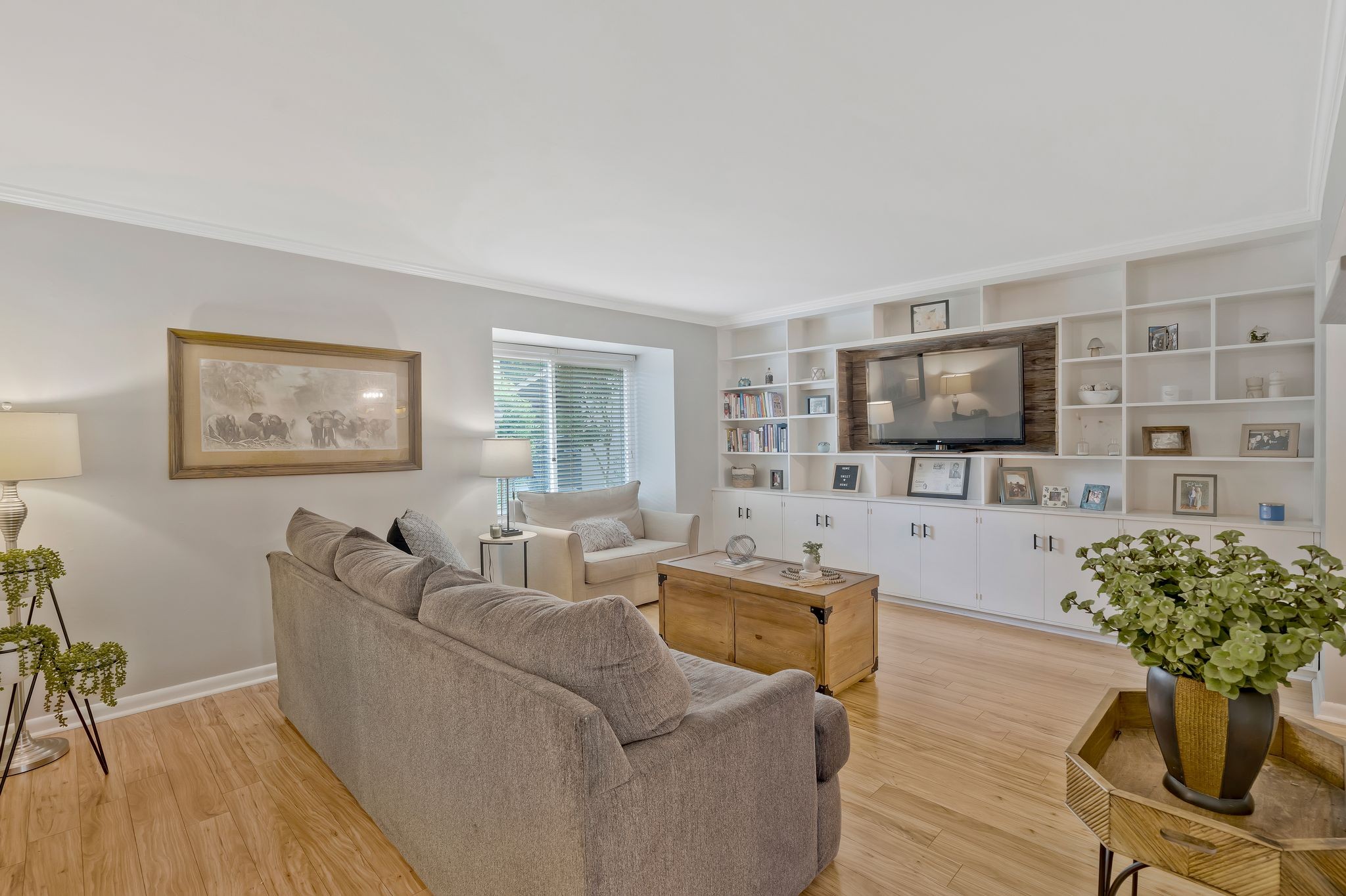 a living room with furniture a flat screen tv and a floor to ceiling window