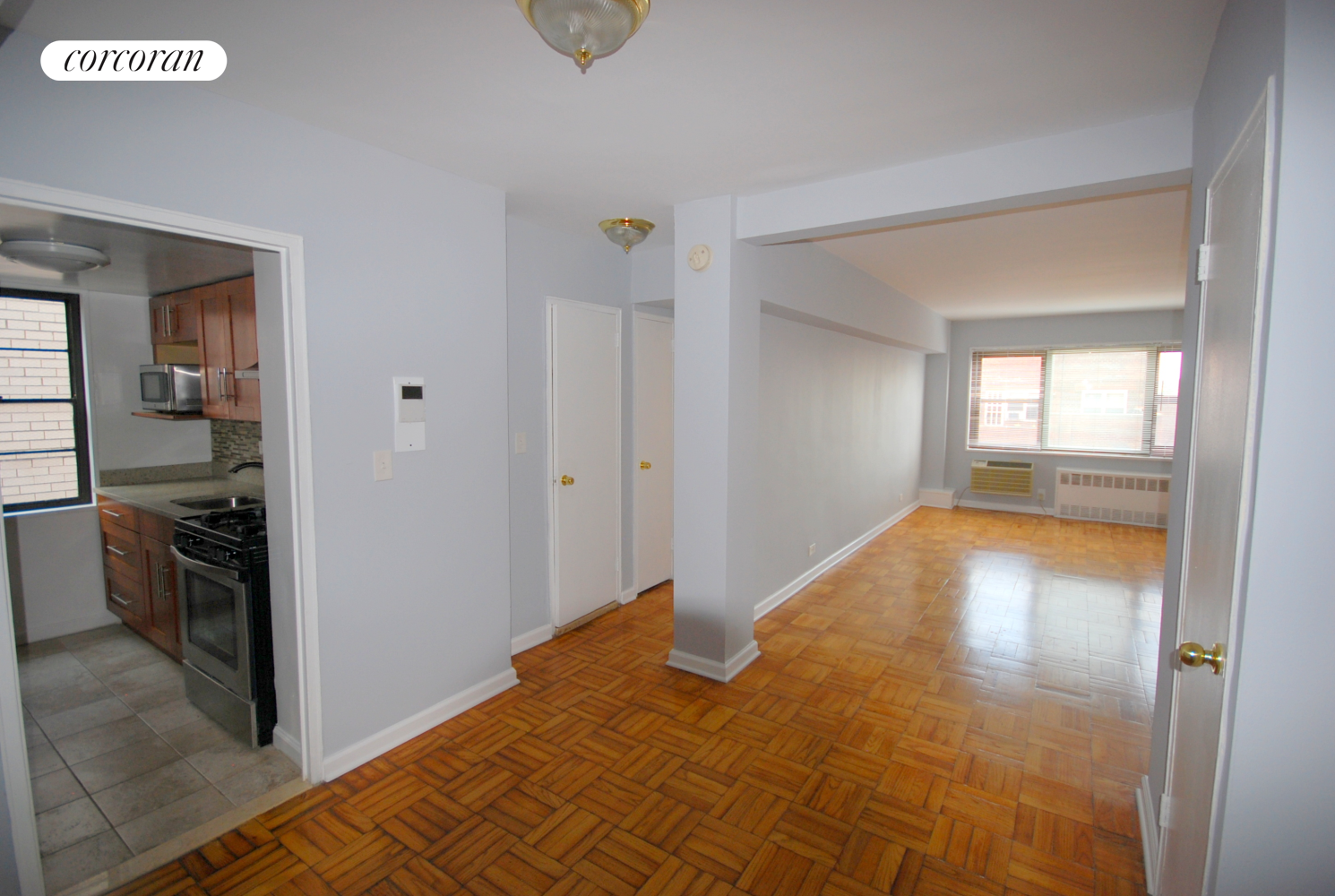 a view of empty room with wooden floor