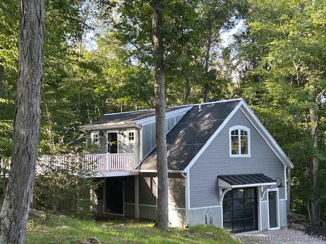 a front view of house with yard and trees in the background