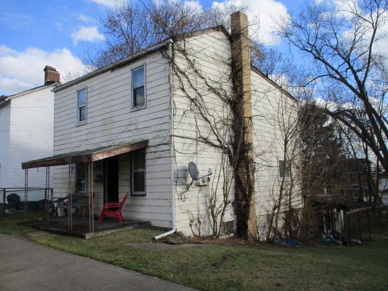 a view of a house with backyard and trees