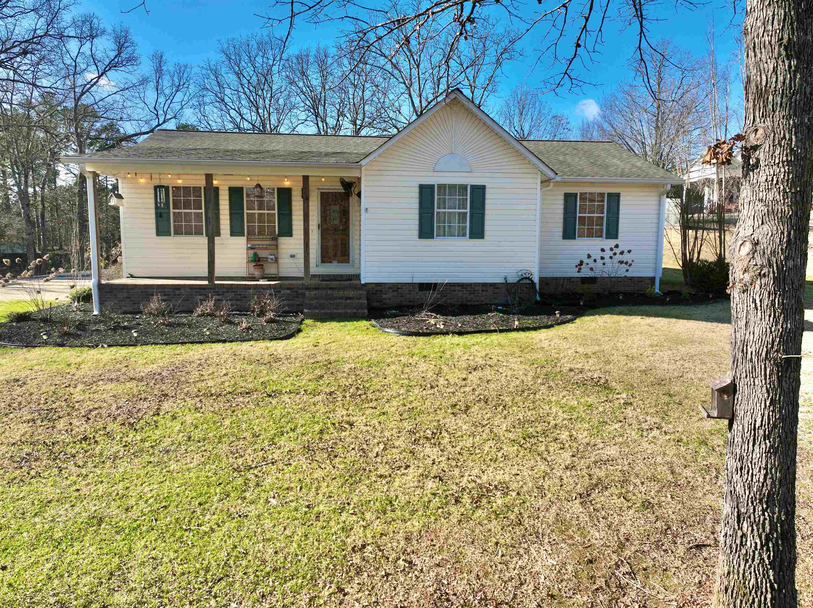 Single story home with a porch and a front yard