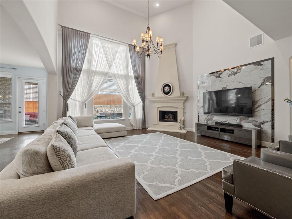 a living room with furniture a flat screen tv and a large window