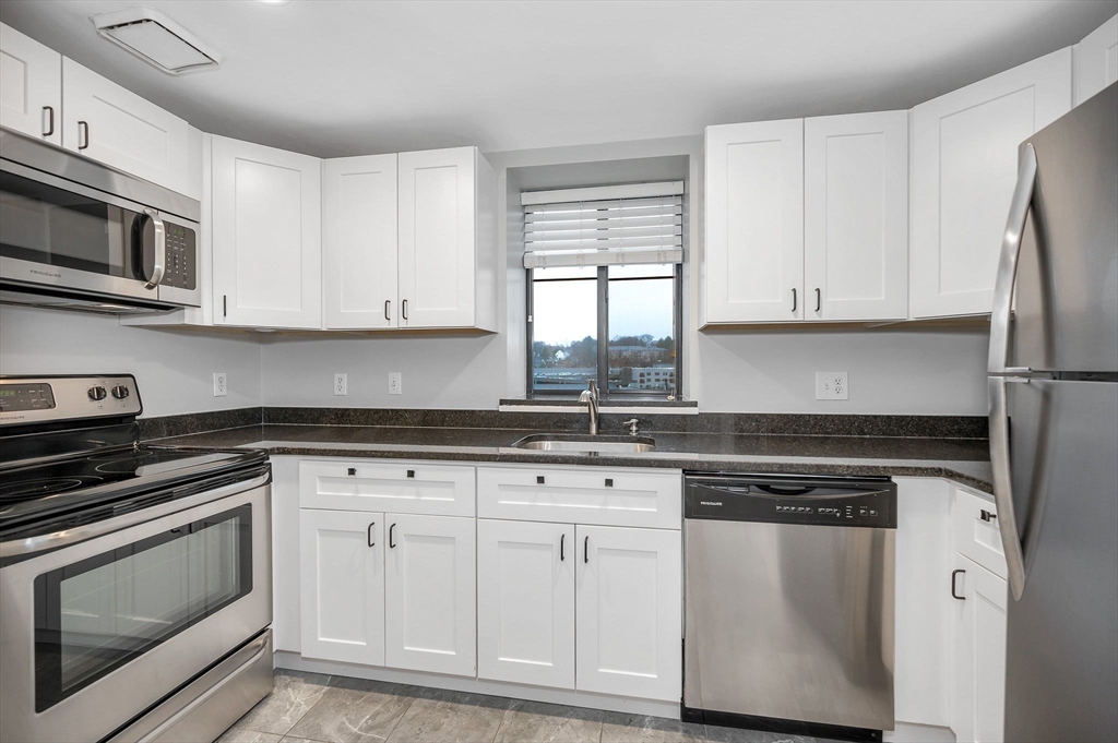 a kitchen with white cabinets and appliances